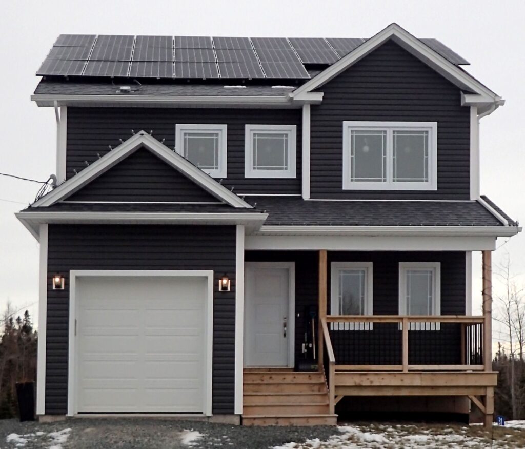 A two-storey dark grey home with solar panels on the roof.
