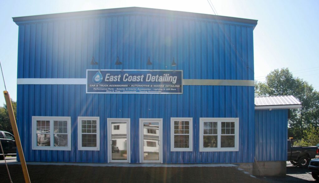 A two-storey building with blue metal siding and white framed windows.