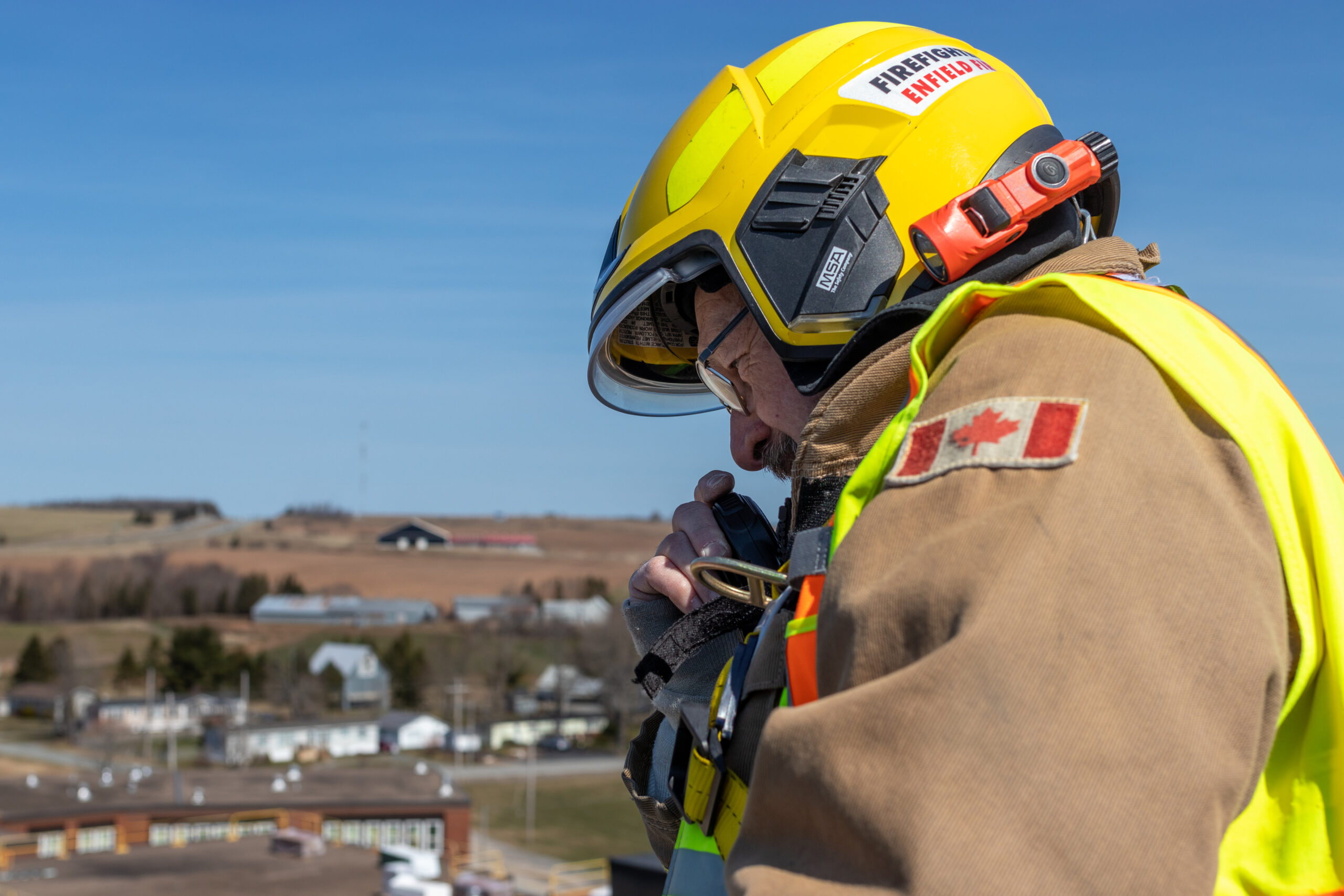 Member of fire service using radio at top of aerial ladder