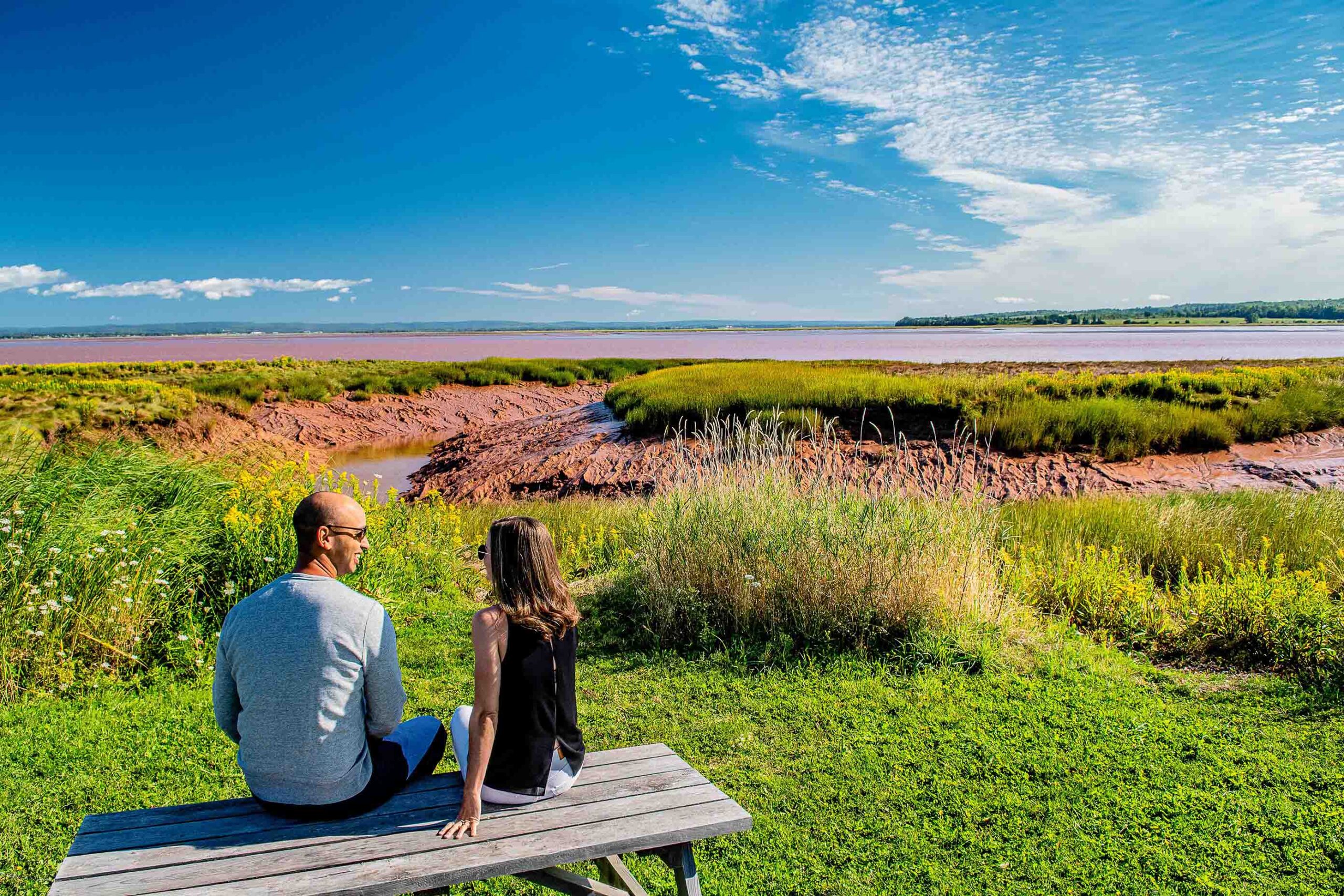 Couple sitting on a picnic table next to tidal inlet