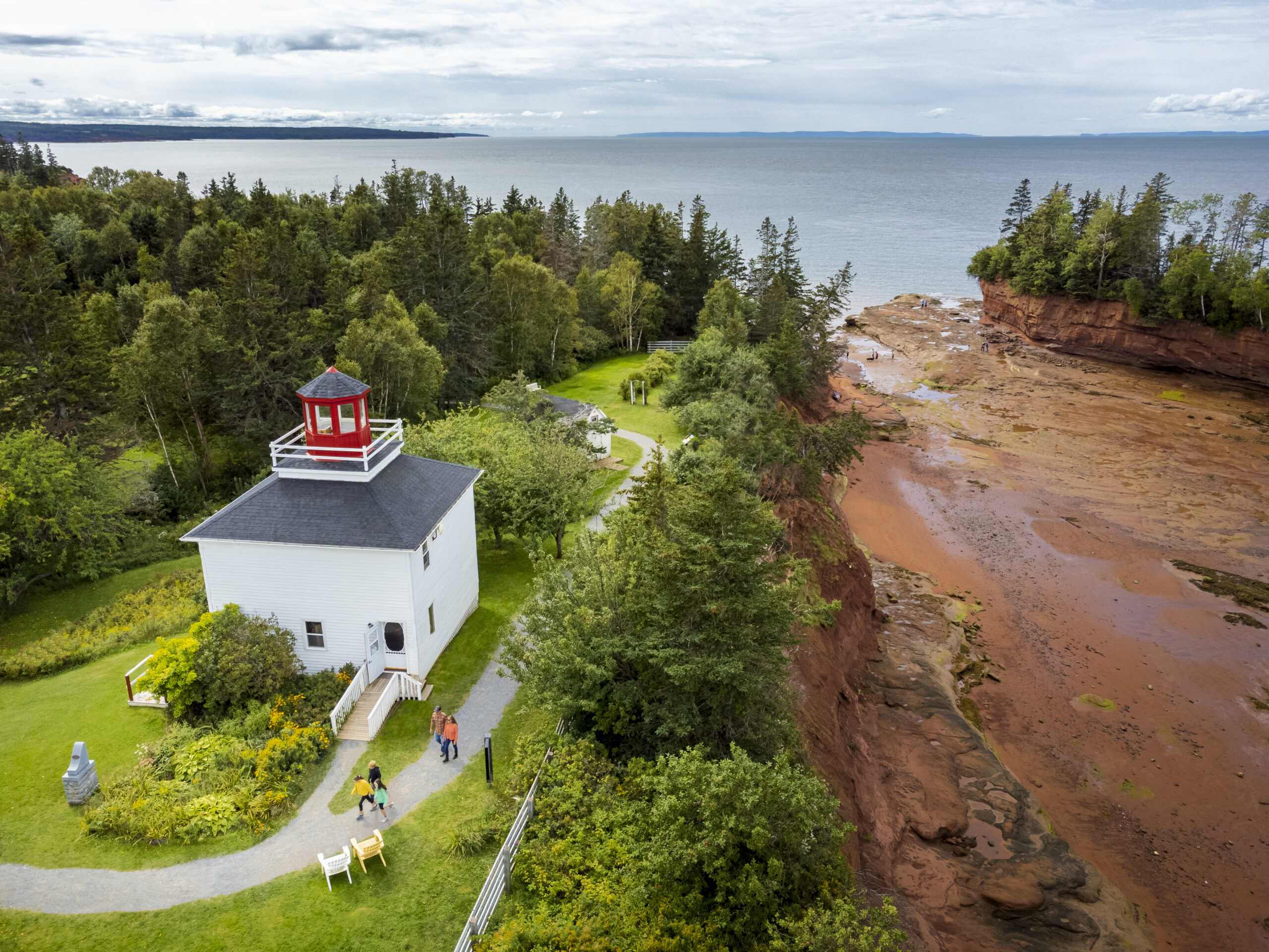 an aerial shot of the ocean floor and light house at burntcoat head park