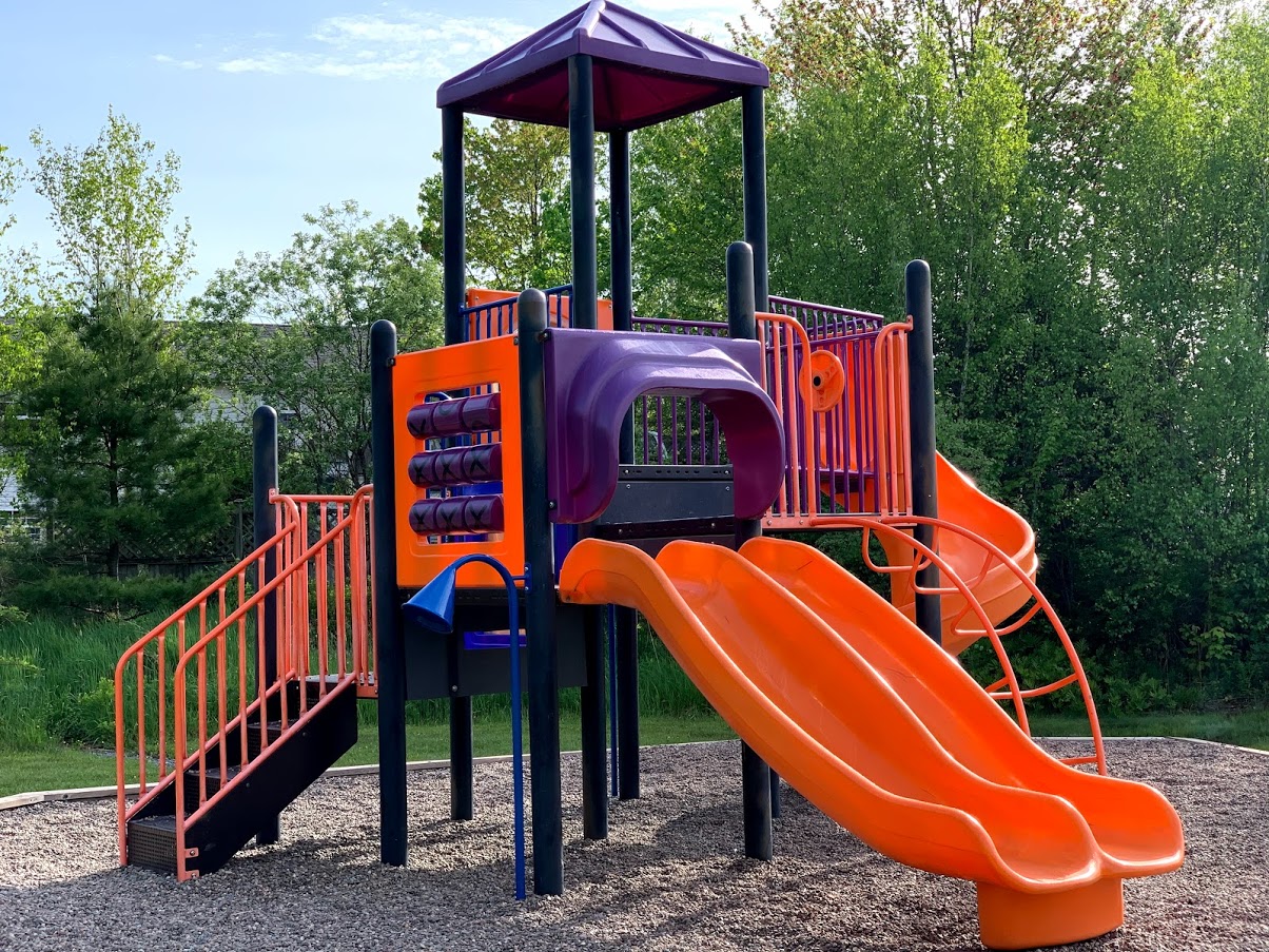 a close up photo of a purple and orange slide on a playground