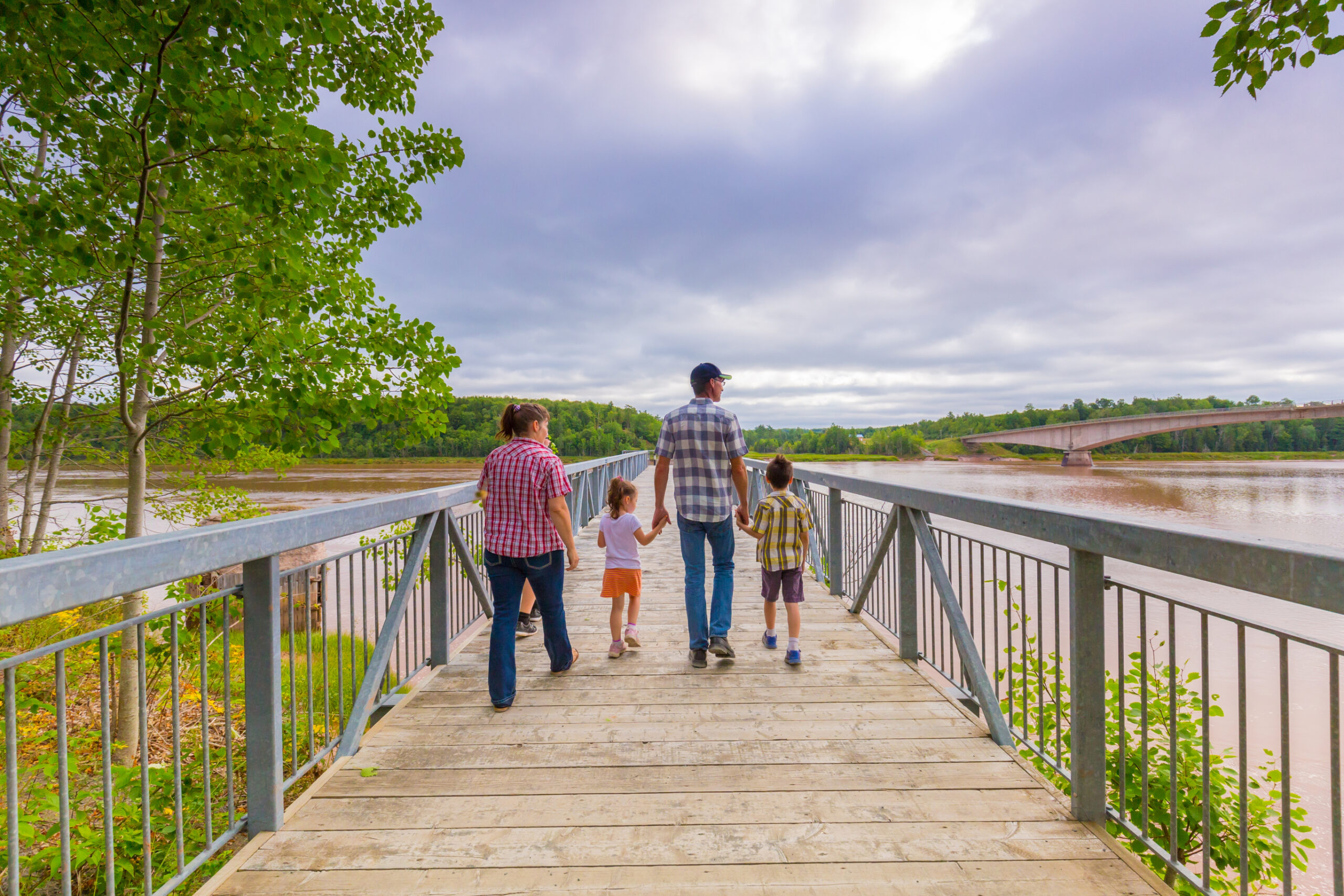 a family of four strolls down a boardwalk at the fundy tidal centre in East Hants