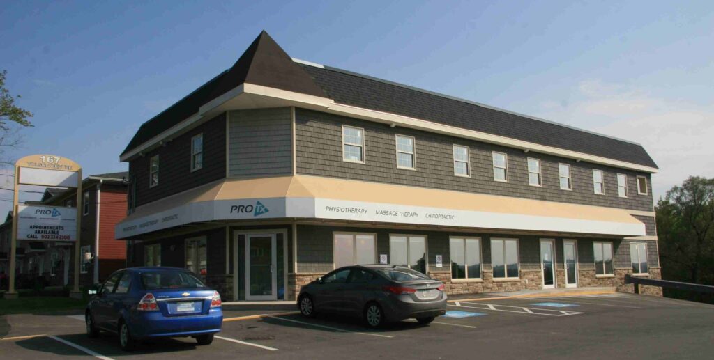 A long two-storey office building with grey siding and a beige awning.