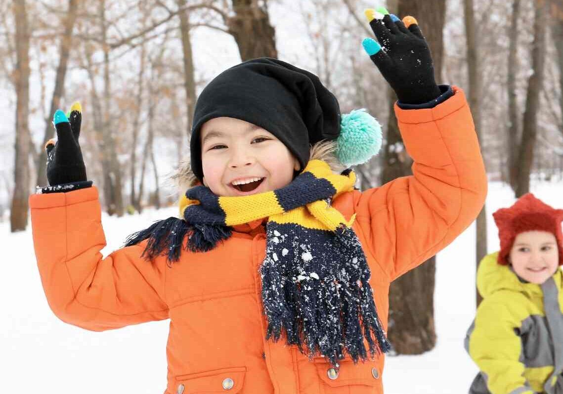 Smiling child in an orange winter coat