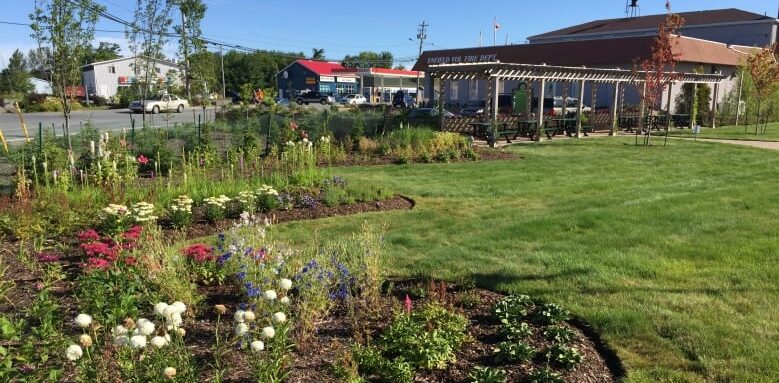 A park with beautiful and well-kept flower beds and long pergola.