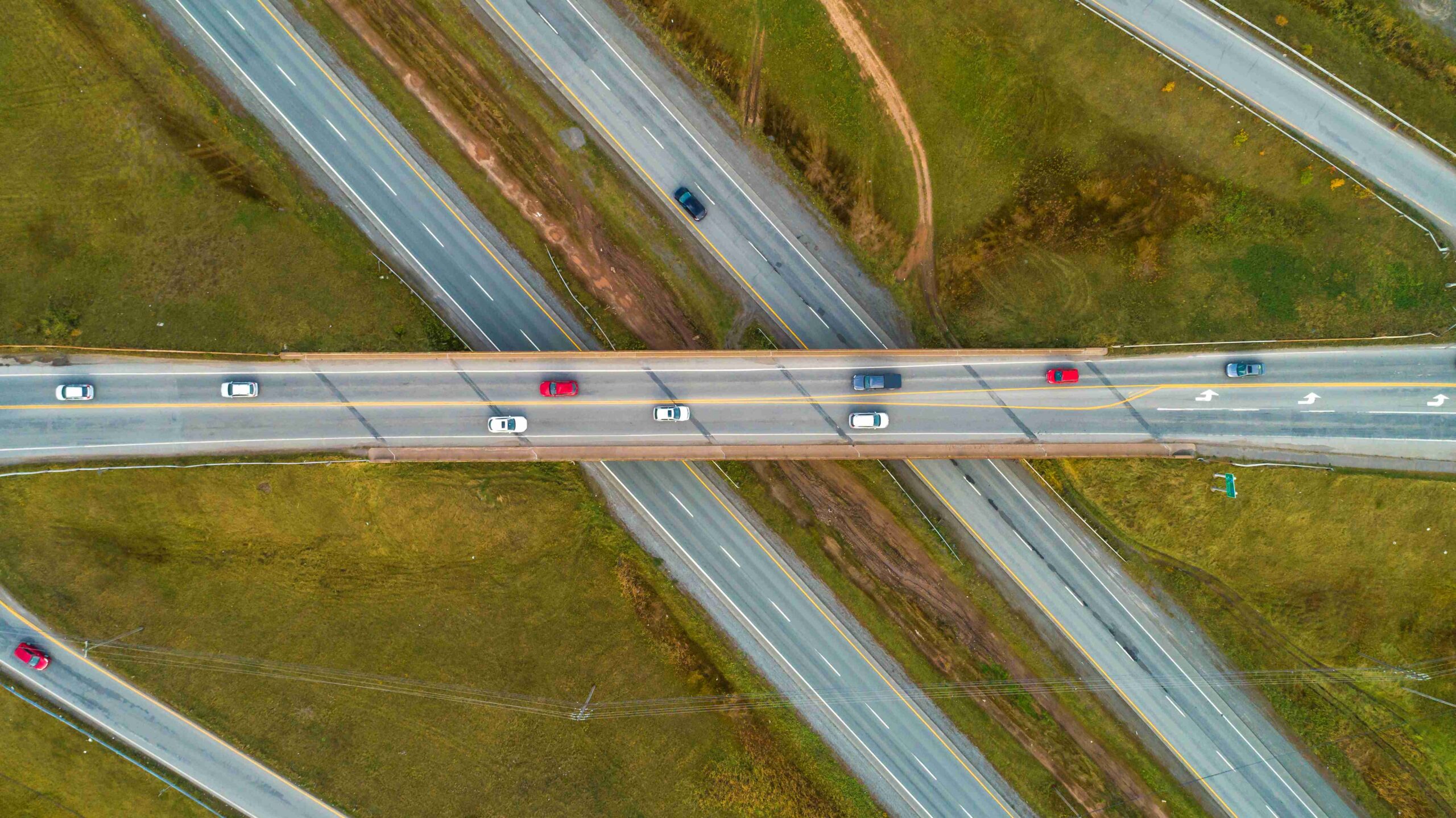Aerial view of a twinned highway and overpass with cars driving
