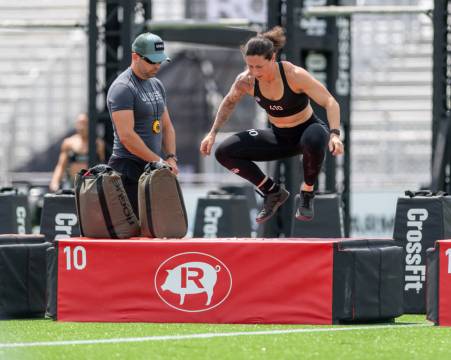 A woman in sportswear jumping as part of a CrossFit competition